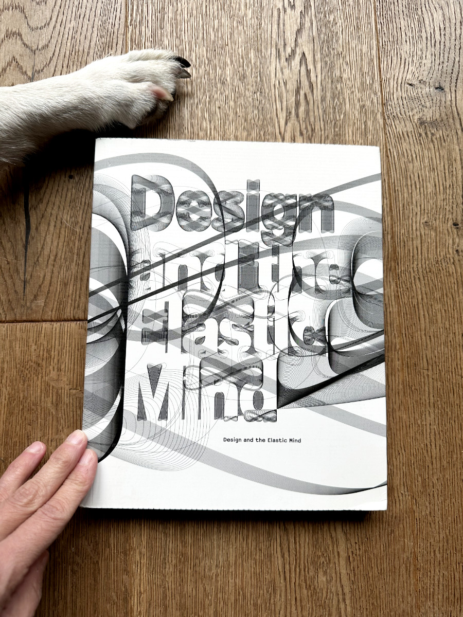 Design-and-the-Elastic-Mind Photograph of the Book Design and the Elastic Mind, featuring a dog paw